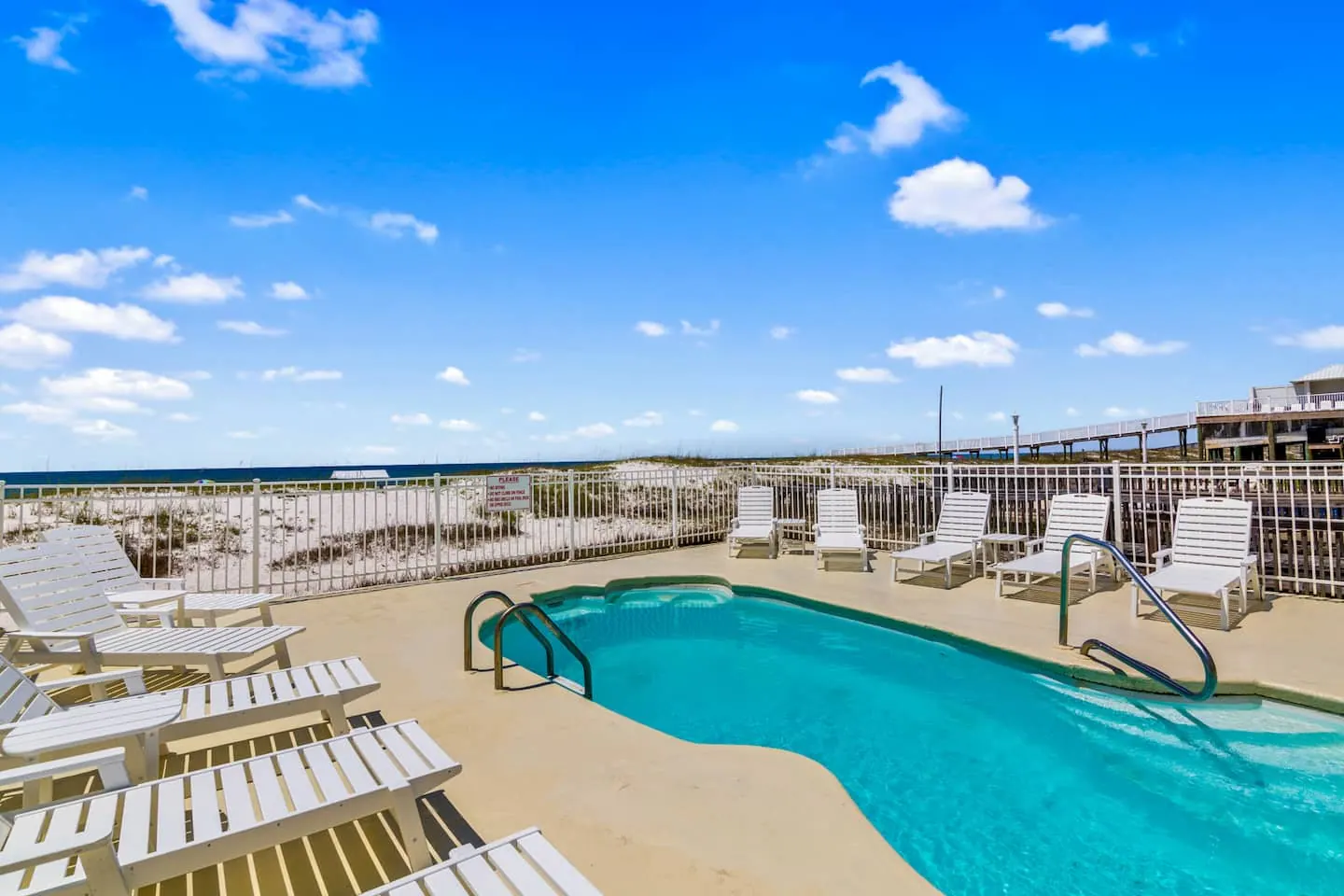 Dolphin View's beachside pool with loungers and the Gulf beyond